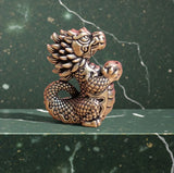 BKB Custom Gifts cute standing brass dragon figurine with detailed scales and horns on a green marble surface