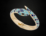 Gold-tone hinged snake bangle bracelet with blue and turquoise geometric enamel inlay.